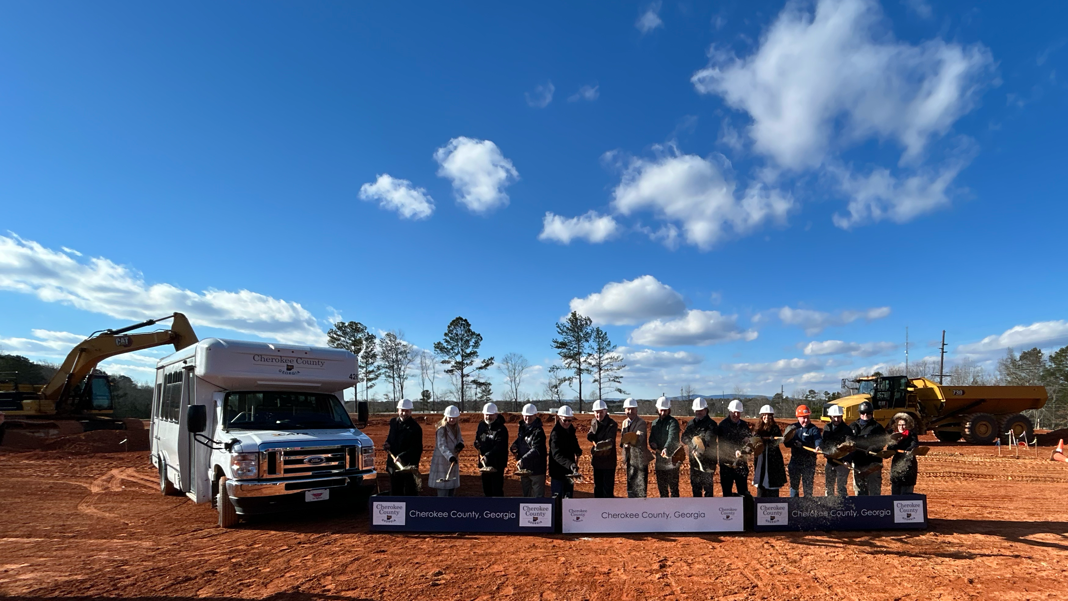 group of people tossing dirt with shovels